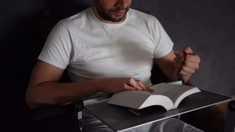 A 30-year-old man reads the Bible and prays in bed, morning routine Stock Footage 294523012