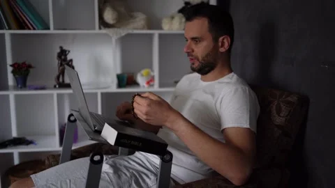 A 30-year-old man reads the Bible and prays in bed, morning routine Stock Footage 294523016