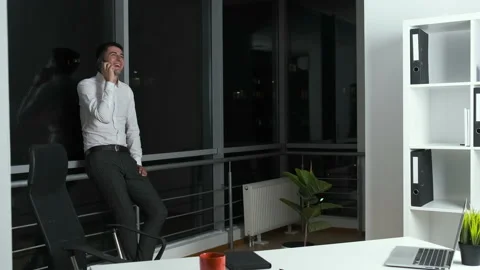 30-year-old man standing by a panoramic window in the office holding a phone in Stock Footage 141143342