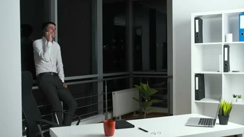 30-year-old man standing by a panoramic window in the office holding a phone in Stock Footage 141260728
