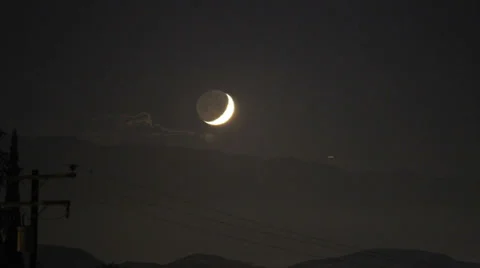 300mm zoom thin crescent moon with earthlight sets behind mountain time lapse Video stock 35845751
