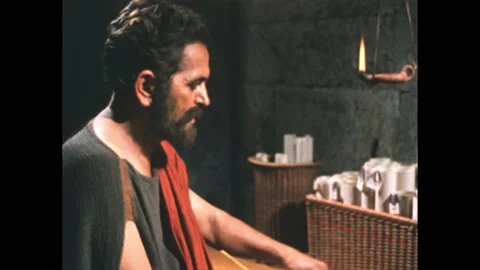 300s BC: Aristotle sits at table writing on scroll. Rolls of scrolls in basket Stock Footage 165357087