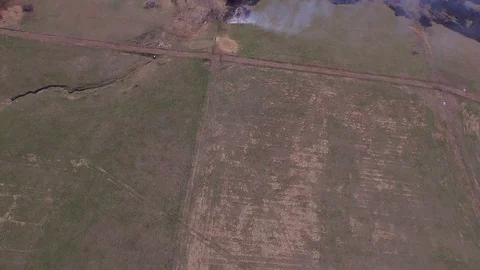 3.08 Controlled Burn Flying Forward Tilting up to Reveal Field 002017 Stock Footage 90257934