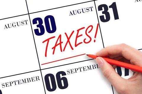 30th day of August. Hand drawing red line and writing the text Taxes on calen Stock Photos