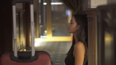 31 A side view of a young brunette sitting on the floor in the hotel corridor. Stock Footage 95033818