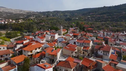 Aerial flyover of Laneia village rooftops towards the historic Orthodox church