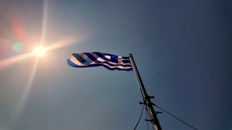 Slow Motion Greek Flag Flying in Wind During Warm Morning Sunlight