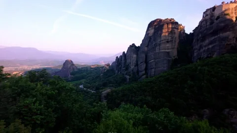 Pan Across Lush Green Meteora Valley with Road and Rock Cliffs