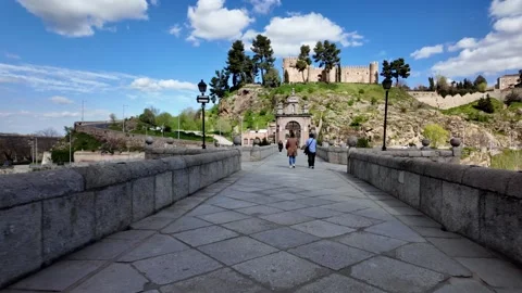 Walking Across Puente de Alcántara Towards Castillo de San Servando, Toledo Walking Across Puente de Alcántara Towards Castillo de San Servando, Toledo