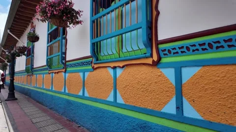 Close Up Pan Along Vibrant Zocalo Murals on Side of Casa Cural Guatape