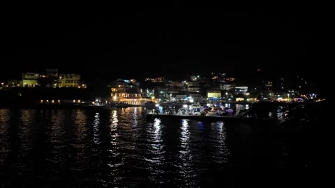 Night View of Kassiopi Harbour in Corfu, Greece with Town Lights Reflected on Wa Night View of Kassiopi Harbour in Corfu, Greece with Town Lights Reflected on Wa