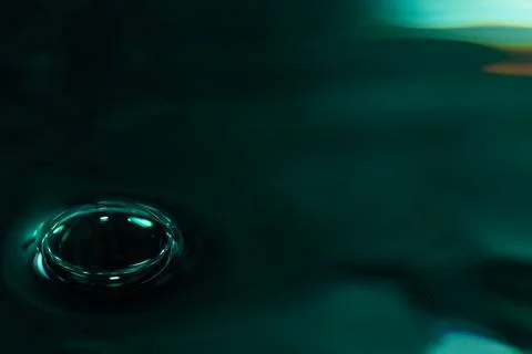337.Single Bubble on Dark Teal Reflective Liquid Surface 写真素材