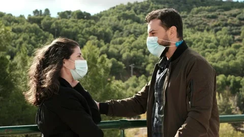 A 35-40-year-old couple kisses outdoors with a face mask in times of a flu, c Stock Footage 141793458