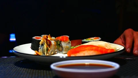 357 Close-up girl dips the rolls into the soy sauce on a black background. Stock Footage 88697250
