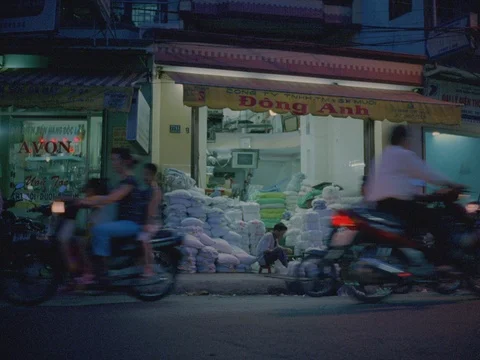 35MM 2K EXT DUSK-SAIGON VIETNAM- SHOPKEEPER W FG TRAFFIC Stock Footage 75374775