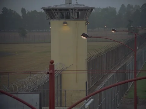 35MM 2K EXT. DUSK STATE PRISON- PUSH IN GUARD TOWER AND FENCES Stock Footage 75364212
