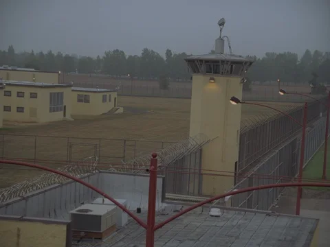 35MM 2K EXT. DUSK STATE PRISON- MS TOWER AND GROUNDS- CAM CRANES OVER PRISON  Stock Footage 75364320