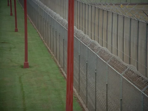 35MM 2K EXT. DUSK STATE PRISON-CLOSE ON PERIMITER FENCES Stock Footage 75364501