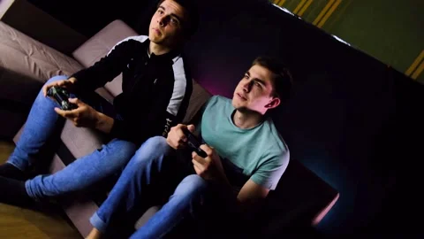 360 barrel camera roll. Two young guys are sitting on the couch in front of the Stock Footage 131173608