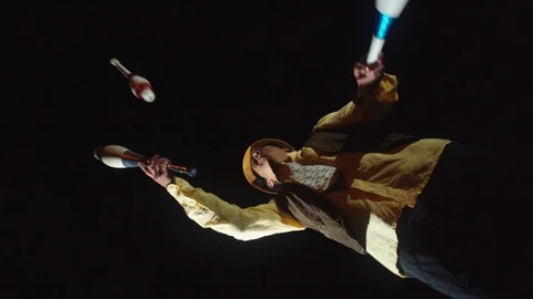 360 degree low angle rotation shot of magician juggling in the darkness in Stock Footage 113938893