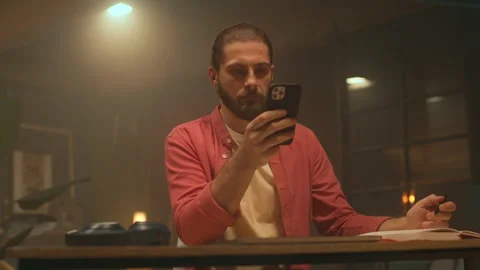 360 degree tracking shot of handsome young bearded man holding smartphone and Stock-Footage 277585573