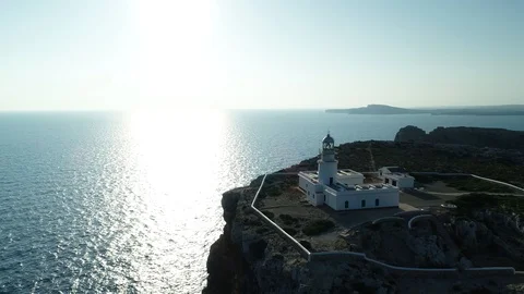 360 drone flight around a lighthouse on the edge of a cliff Stock Footage 119881915