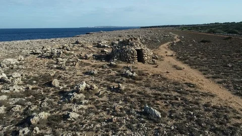 360 drone flight around a stone shelter on the island of menorca Stock Footage 117632485