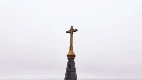 360 looping around a brass crucifix cross on top of a church steeple with shingl Stock-Footage 325530572
