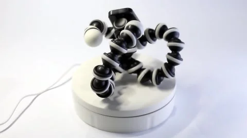 360° Rotation Video of Black Elastic Mini Tripod on White Background Stock Footage 300550428