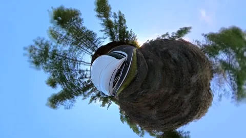 360 spherical video with "Tiny Planet" effect of white car driving Stock Footage 297887047
