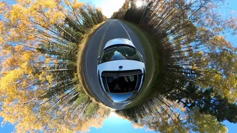 360 tiny planet type view looking down on a white car driving on a road through  Stock Footage 299061166