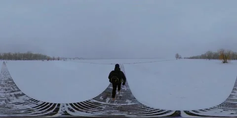 360 TPV  person walks along the path on a snowy and deserted beach Stock Footage