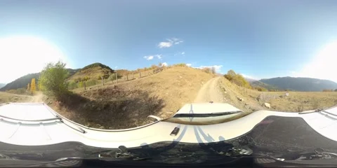 360 vr A car drives through a mountain range on a sunny day Stock Footage 167425357