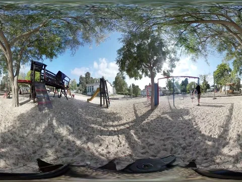360 VR footage of children playing in a playground Stock Footage