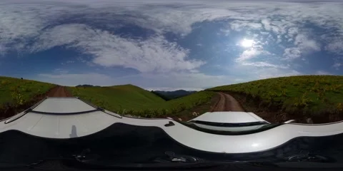 360 VR An SUV drives on a dirt road along green meadows Stock Footage 167258995