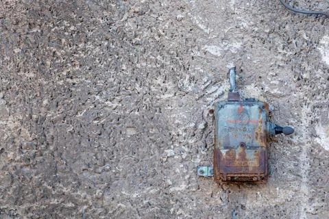 380 volt electrical switch located on an old rough plastered wall Stock Photos