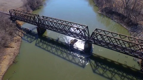 3.98 4K Tilt down Over Railway Bridge Moving Downstream 000913 Stock Footage 90258923
