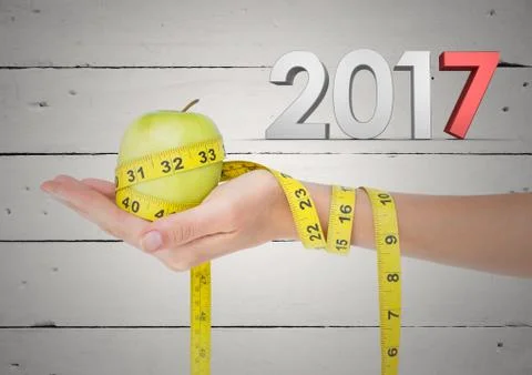 3D 2017 and hand holding green apple wrapped with measuring tape Stock Photos