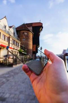 3D effect: Old crane protrudes from smartphone, tourist guide concept. Stock Photos