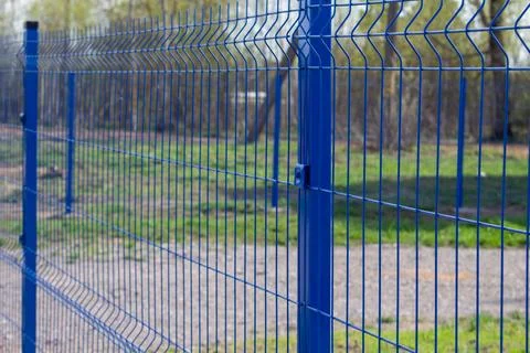 3D fencing sections made of welded mesh in blue. Fragment of a fencing sectio Stock Photos