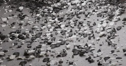 3D illustration of a textured surface strewn with many small stones on a san Illustrazione stock