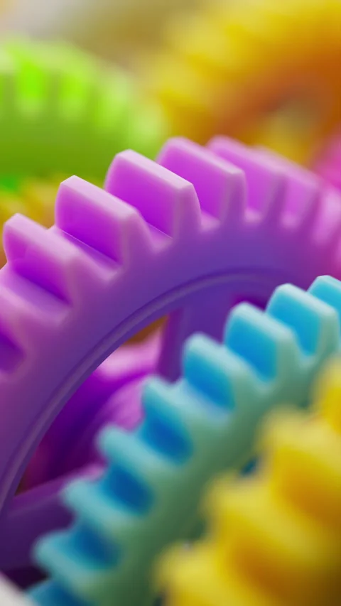 3D looped close up of bright plastic gears rotating in soft focus. Stock Footage 315523825