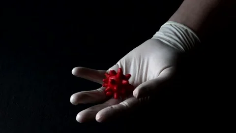 3D model of red coronavirus lies on hand in white medical disposable latex Stock Footage 152565344