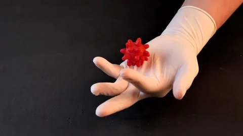 3D model of red coronavirus lies on hand in white medical disposable latex Stock Footage 152565416