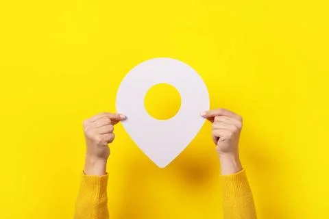 3d pin in hand white map pointer 3d pin in hand over yellow background Cop... 库存照片