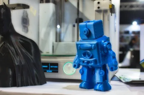 3D printed robot model next to a 3d printer at a technology and gadget fair Stock Photos