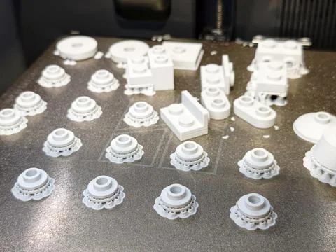 3D printed white plastic prototype parts on build plate 库存照片