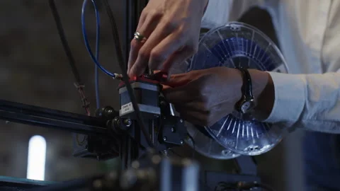 3d Printer and a Woman Preparing the Reel Stock Footage 262504762