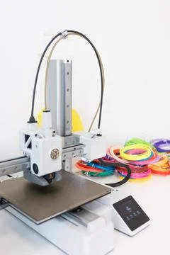 A 3D printer creates objects with colorful bands and innovative designs using Stock Photos