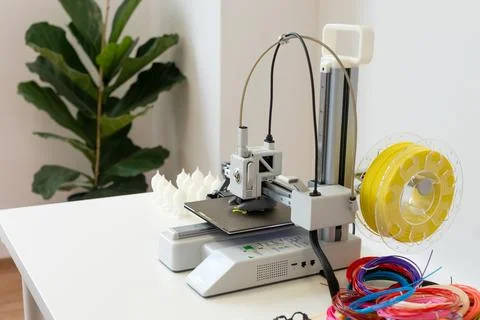 A 3D printer creates objects with colorful bands and innovative designs using Foto stock